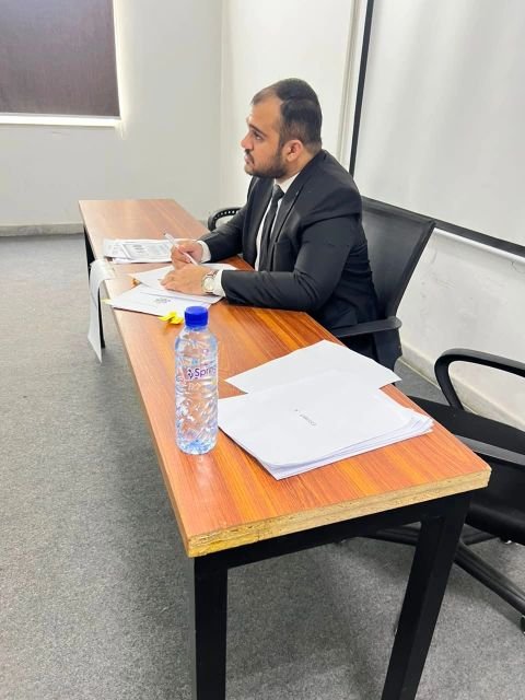 Farrokh Mushtaq reviewing case materials as adjudicator